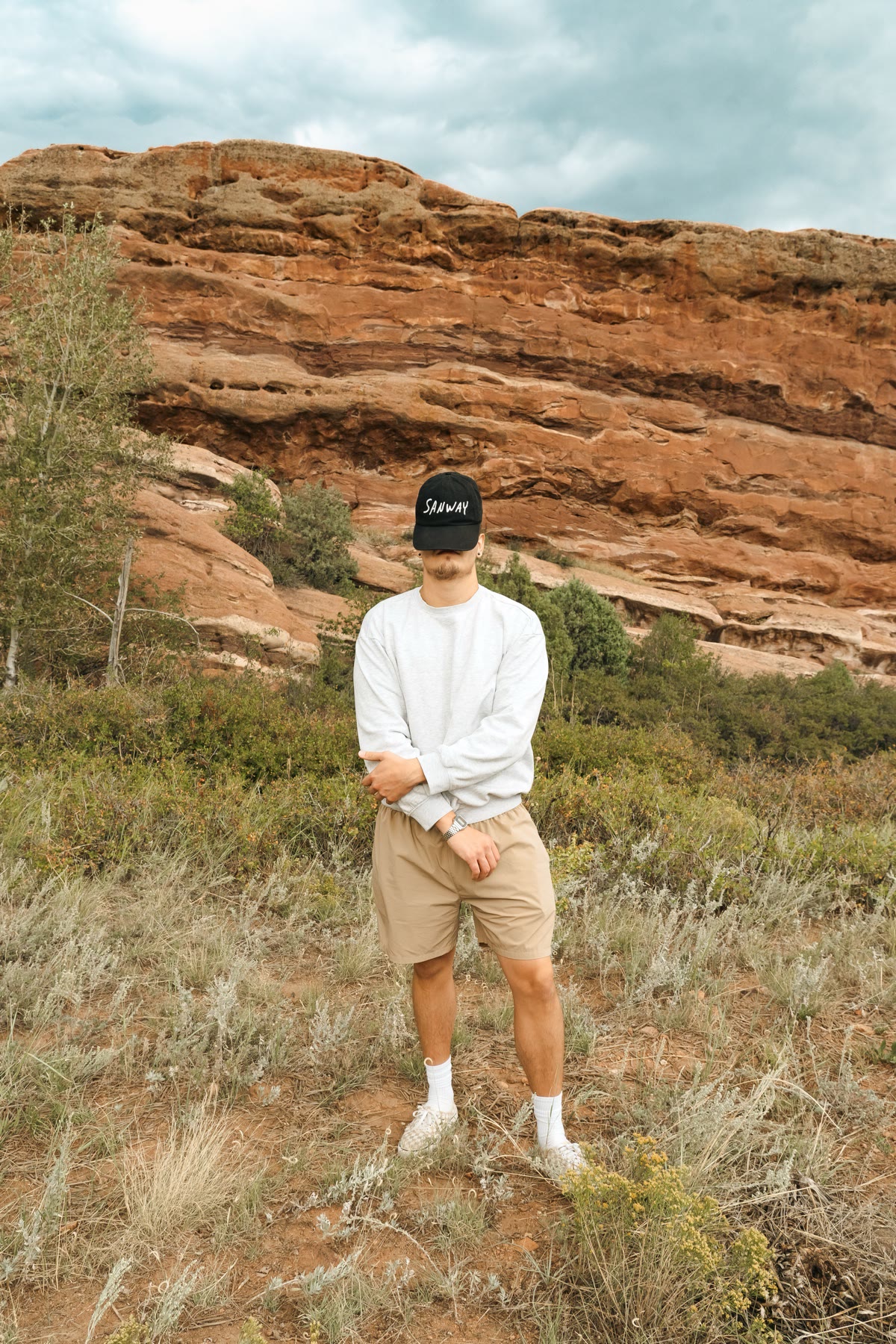 Nate Sanway in a SANWAY cap standing in front of red rock cliffs